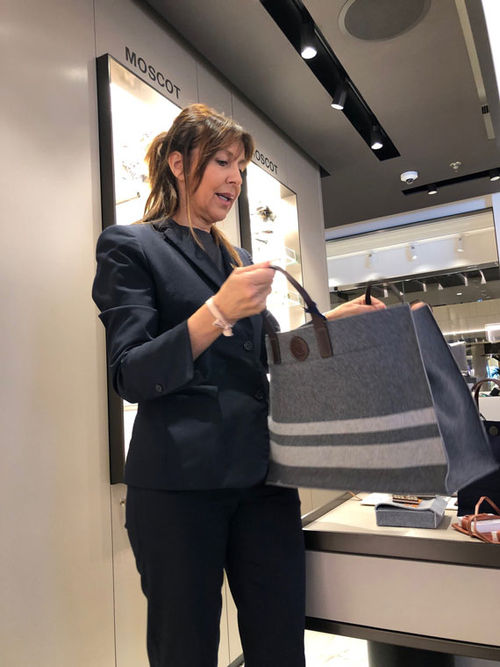 Maria Antonietta Franzini, a sales agent at The Journey shop on the Explora I, displays a women's handbag that sells for 535 euros.